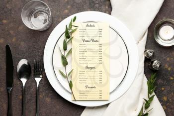 Beautiful table setting with menu on grey background�