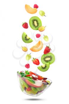 Delicious fruit salad in bowl and flying ingredients on white background�