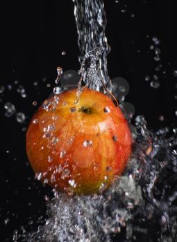  fresh apple in water stream on   black background