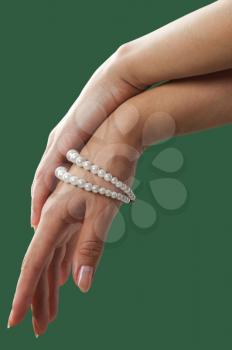 image of beautiful nails and woman fingers with pearls isolated on green