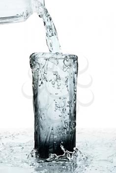 glass of a water with overflow on white background