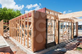 New residential construction home framing against a blue sky