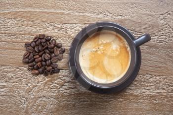 Coffee cup and beans on grunge wooden background