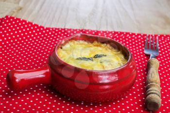 julienne with mushrooms, cream and cheese on red polka dot tablecloth in country style