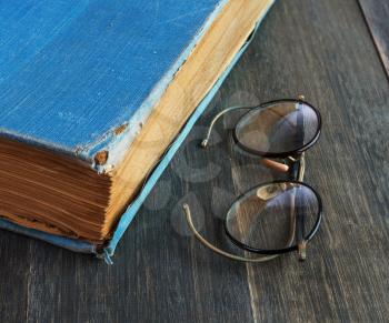 
retro glasses and old book  on a wooden background