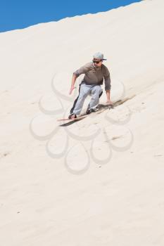 
Sandboarding at sand dunes in Little Sahara, Kangaroo Island, South Australia.Focus on the man 
