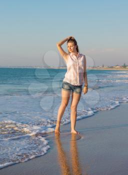 Beautiful girl on the summer beach  in the evening light
