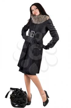 Royalty Free Photo of a Woman in a Coat With a Bag on the Ground
