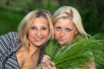 Royalty Free Photo of Two Girls Holding Grass