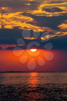 Red sunset over a calm sea bay surface