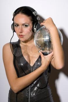 Portrait of woman in headphones with a mirror ball