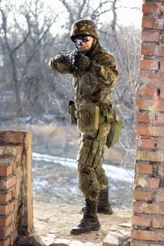 Soldier near wall with a gun in his hands