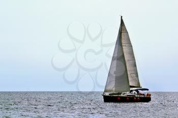 Small sailing yacht on the sea waves