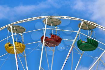 Three cabins Ferris wheel on a background of blue sky