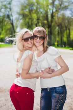 Young smiling women wearing sunglasses and white t-shirts
