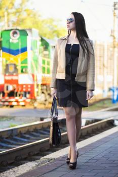 Beautiful young woman posing at the railway station