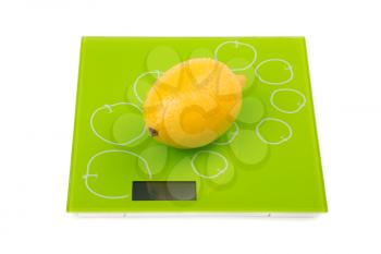 Yellow lemon on square kitchen scales. Isolated