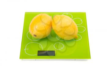 Two yellow lemon on square kitchen scales. Isolated