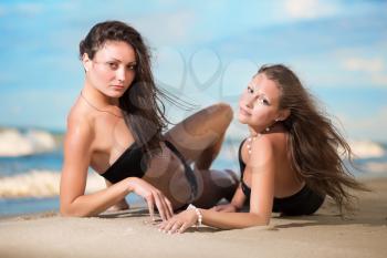 Two sexy women posing on the beach