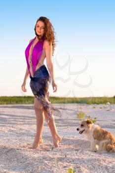 Pretty young brunette walking with her little dog