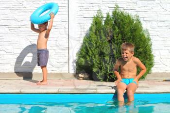 Two brothers near a swimming pool at summer vacation