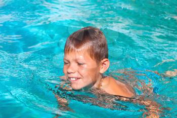 Smiling boy in the swimming pool on summer vacations