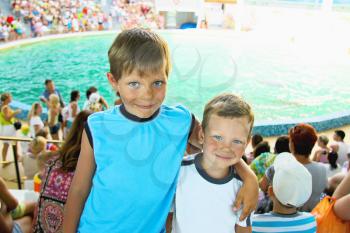 Two joyful smiling boy in the dolphinarium