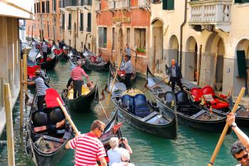 VENICE, ITALY - MAY 06, 2014: Several gondolas with tourists in a narrow channel. Venice, Italy