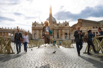 VATICAN CITY , ITALY - MAY 03, 2014: Happy girl jumping in the sunshine on the Saint Peter's Square