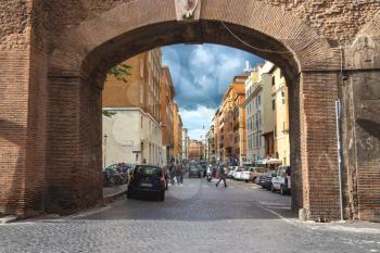 ROME, ITALY - MAY 03, 2014: People on street Via del Mascherino in Rome. Gate in the wall, enclosing Vatican City