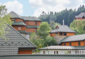 Modern cottages on slope of forested mountains. Carpathians, Ukraine