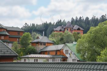 Modern cottages on slope of forested mountains. Carpathians, Ukraine