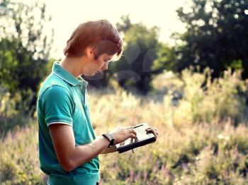 young guy with a tablet outdoors