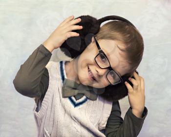 portrait of a little boy in fur headphones