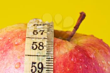 Royalty Free Photo of an Apple and Measuring Tape