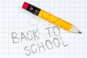 Back to school written on a squared paper with pencil
