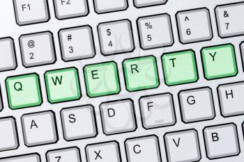 Green qwerty buttons on silver computer keyboard 