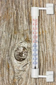 Outdoor thermometer on the old wooden wall