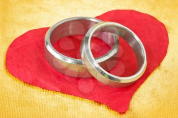 wedding rings on the red crumpled paper heart