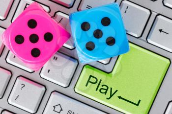 Online gaming concept. Red and blue dice on the computer keyboard.