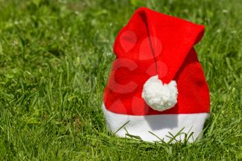 Red Santa's hat on the green grass
