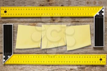 Right angle square tools and sticky notes on wooden background
