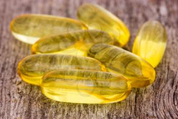 Pile of fish oil capsules on the wood background