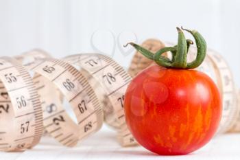 Healthy lifestyle concept with measuring tape and red tomato