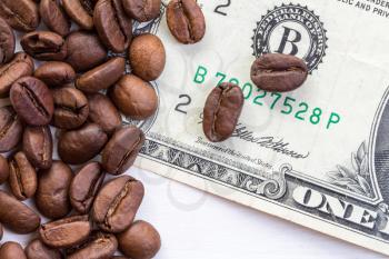 Coffee beans scattered on dollar. The concept of the price of coffee on the market