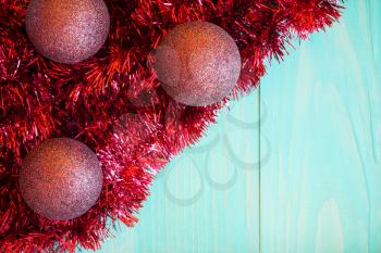 Red tinsel and Christmas balls on blue background