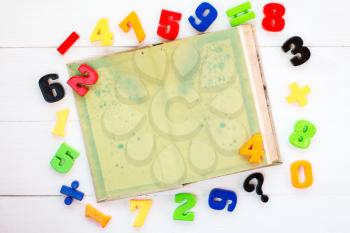 Colorful plastic numbers and open book with copy-space