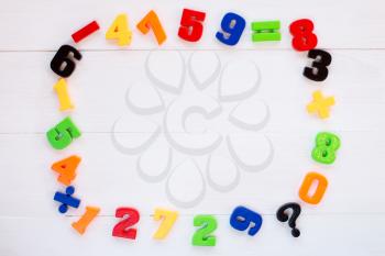 Colorful plastic numbers laid on wooden background