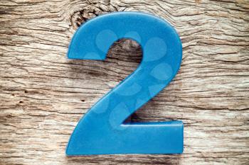 Blue number two on the wooden background
