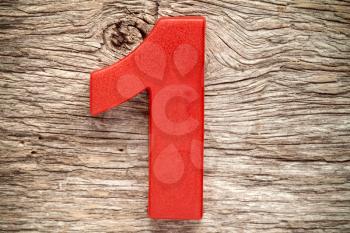 Red number one on the wooden background